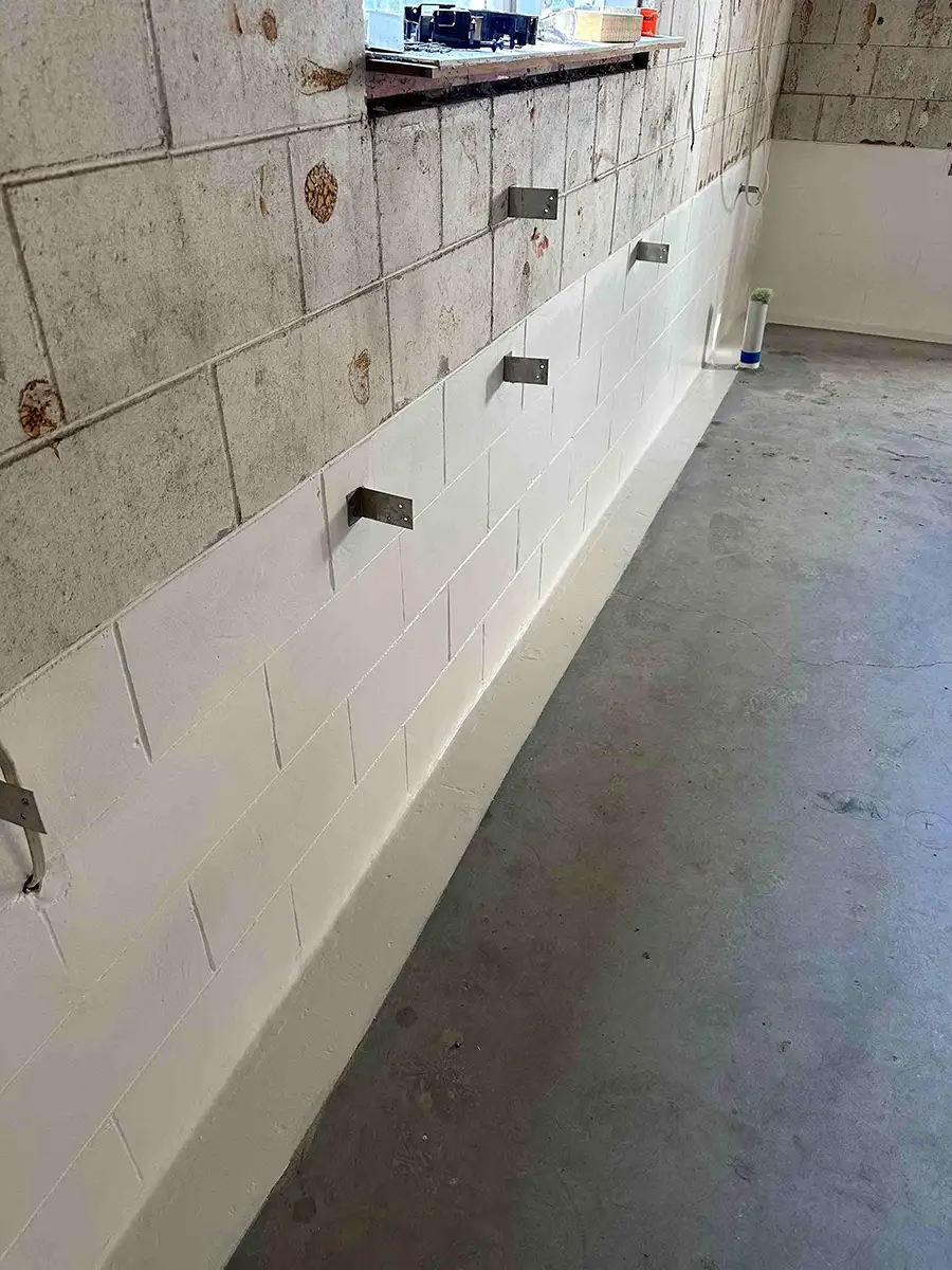 Waterproofing coating applied to lower section of concrete block basement wall